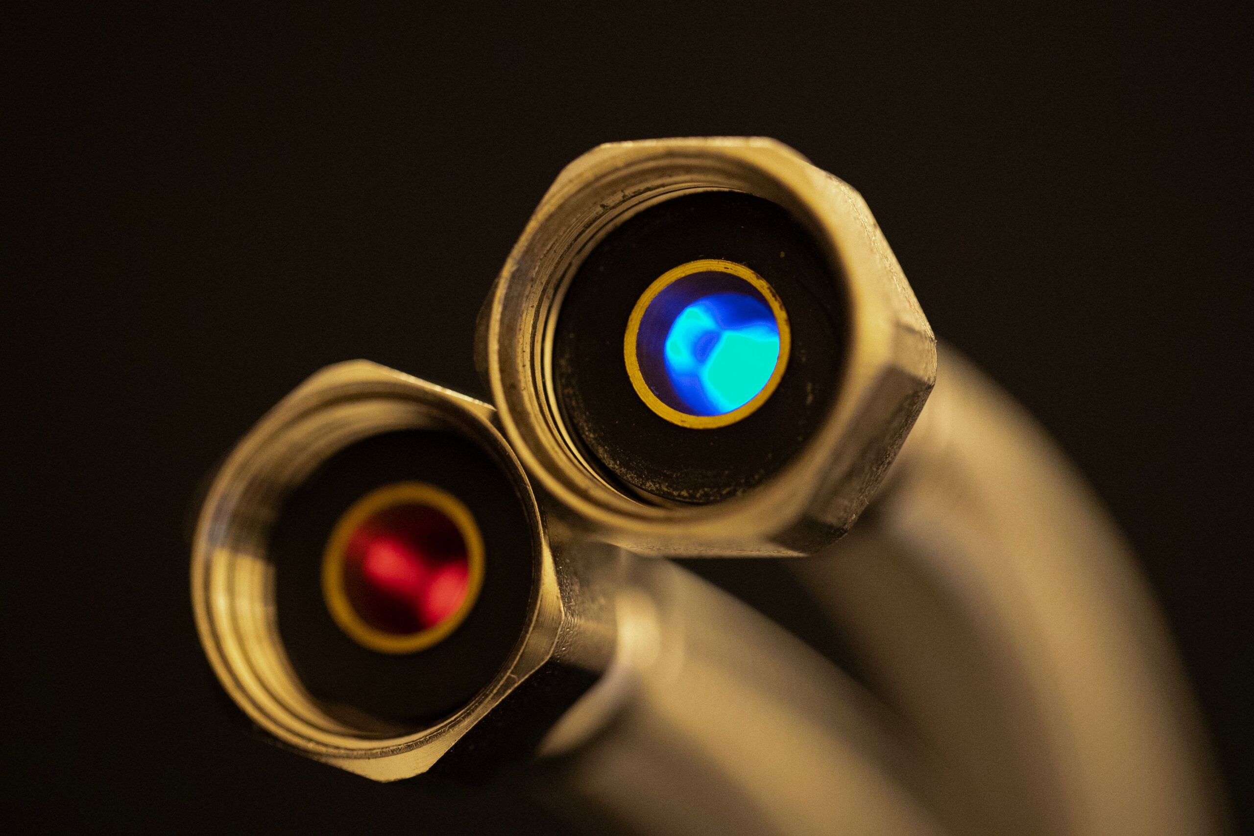 Detailed shot of optical lenses reflecting blue and red light, showcasing precision technology.